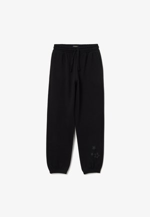 Schwarze Jogginghose mit elastischem Bund und verstellbarem Kordelzug. Mit Sternmotiven am linken Bein. Aus weichem Stoff gefertigt.