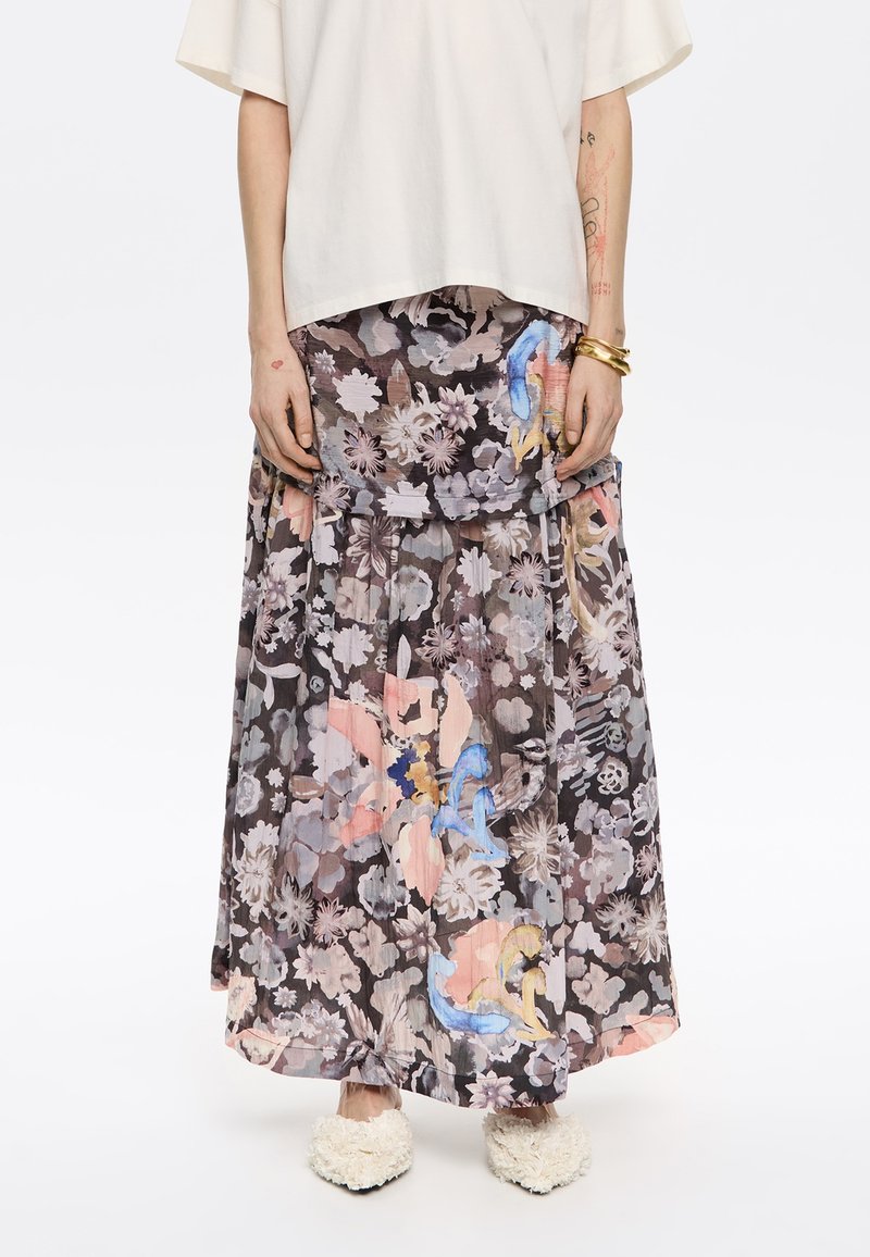 Falda maxi fluida y floral en tonos oscuros con acentos en rosa claro y azul. Tejido ligero y texturizado con un diseño en capas.