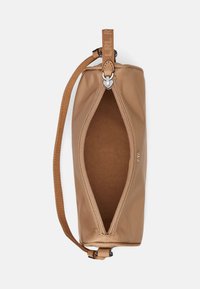 Brun tygpås med en texturerad utsida, dragkedjestängning upptill och ett sidhandtag. Insidan har en slät foder.