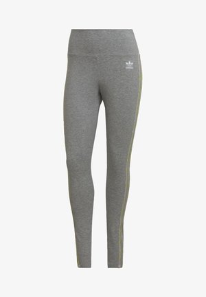 Szare legginsy sportowe z wysokim stanem, o gładkiej teksturze i kontrastowych jasnych paskach po bokach. Logo Adidas na biodrze.