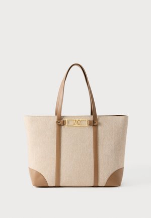 Beige Tragetasche mit hellbraunen Ledergriffen und Besatz, goldfarbene rechteckige Logoplatte mit den Buchstaben "A|X" in der Mitte vorne.