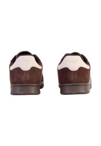 Bruine suède sneakers met witte lederen accenten, afgeronde vorm en gladde rubberen zolen. Beschikt over subtiele branding op de achterkant.