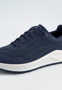 Navy Laufschuh aus Mesh und Gummi, mit einer strukturierten Oberseite, weißer Zwischensohle und Schnürsenkeln in einem eleganten Design. Minimale Markenkennzeichnung vorhanden.