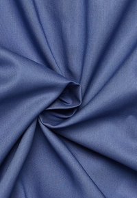 Tessuto blu navy con una superficie liscia, che presenta una leggera lucentezza. Il materiale è arricciato in pieghe, enfatizzando la sua morbida caduta.