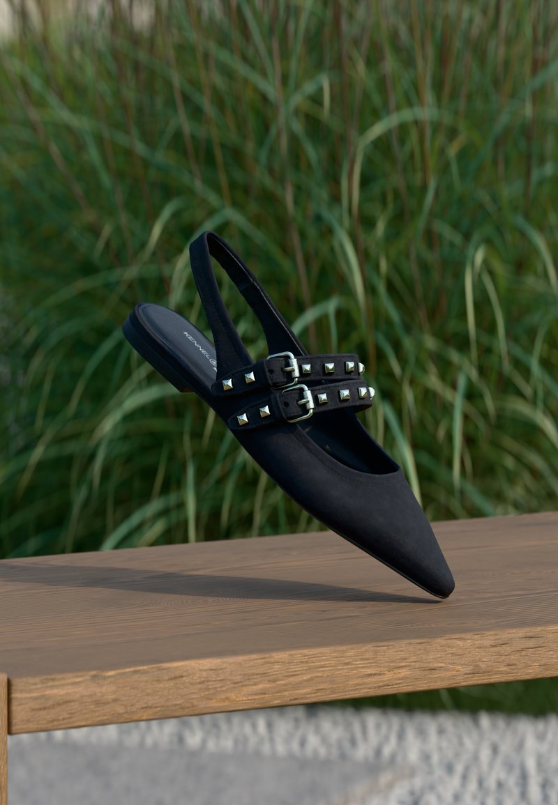 Μαύρο σουέντ παπούτσι με λουρί πίσω και μυτερή μύτη, με δύο λουριά με ασημένια πυραμιδοειδή τρουκς και διπλό κούμπωμα.