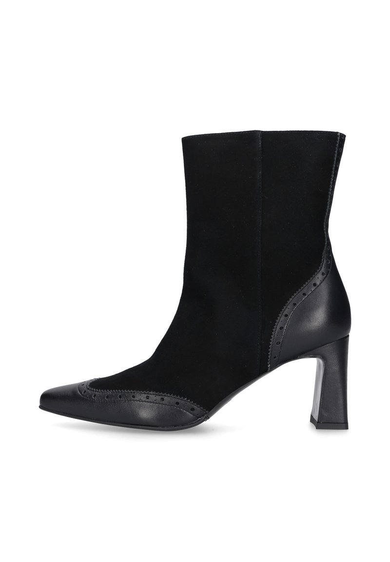 Zwarte enkelboot van een combinatie van suede en leer, met een spitse neus, een hak van 10 cm, brogue-details langs de rand en een gladde afwerking.