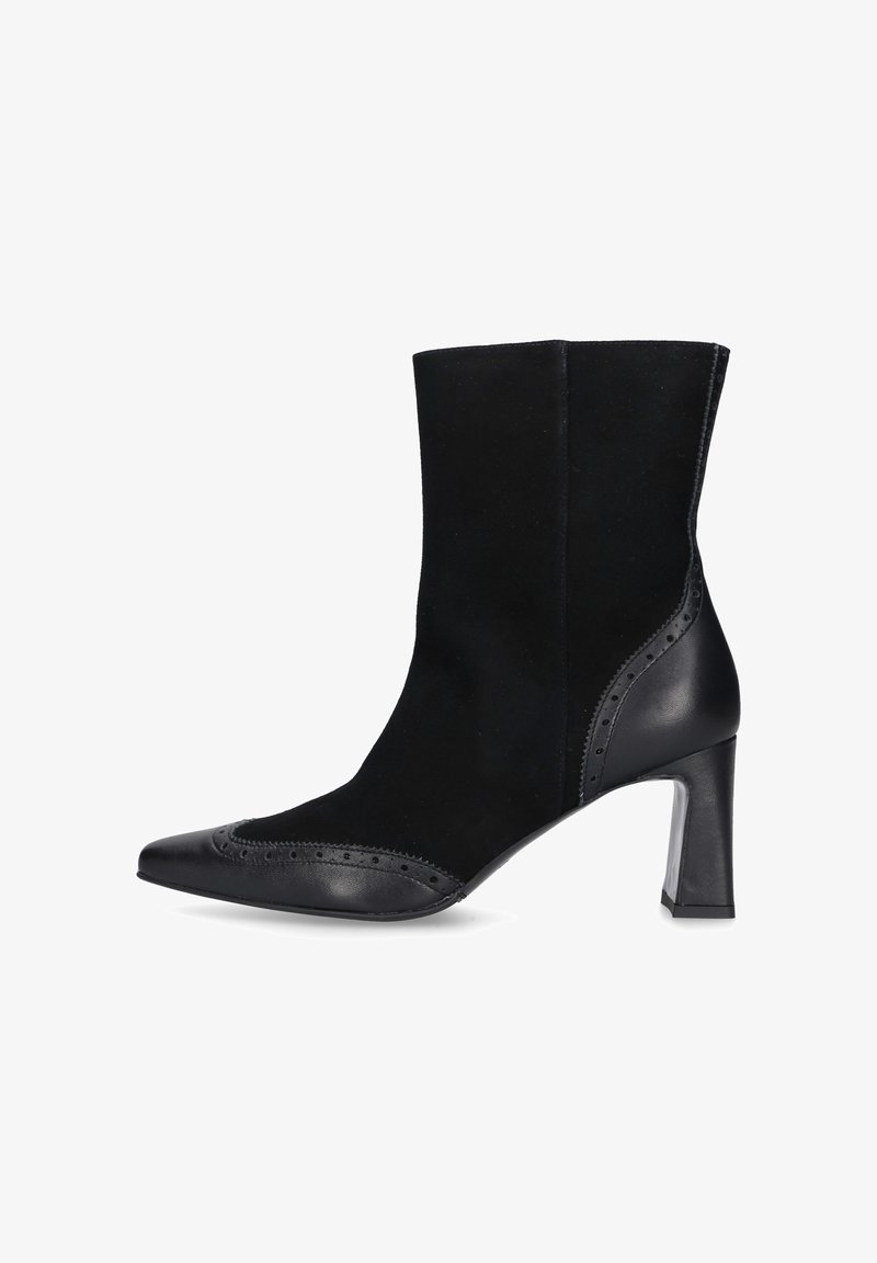 Stivaletto nero con una combinazione di suede e pelle, punta affusolata, tacco di 4 pollici, dettagli brogue lungo il bordo, finitura liscia.