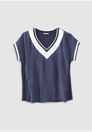 Top azul marino de manga corta con ribete blanco en forma de V en el escote y ribetes blancos a juego en las mangas, colocado plano sobre un fondo gris.