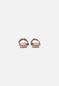 Bruine leren sandalen met een minimalistisch ontwerp, voorzien van twee banden over de voet en een platte houten zool.
