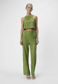 Conjunto de dos piezas verde de encaje, que incluye una blusa corta y pantalones de pierna ancha de talle alto. Patrones florales intrincados, tejido transparente y una silueta elegante.