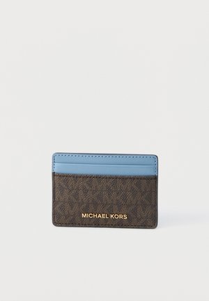 Sottile portacarte Michael Kors con sezione inferiore marrone a motivo e scomparto superiore per carte azzurro chiaro su sfondo bianco.