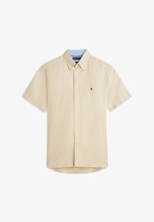 Beige overhemd met korte mouwen, knopen, een kraag, een klein logo op de borst en een lichtblauwe voering aan de binnenkant van de kraag.