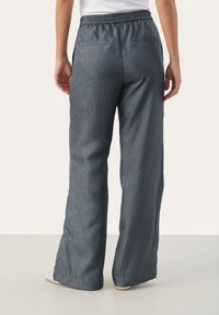 Spodnie o szerokich nogawkach w ciemnoszarym kolorze, wykonane z teksturowanej tkaniny. Elastyczny pas, dwie tylne kieszenie oraz luźna sylwetka zapewniająca komfort.