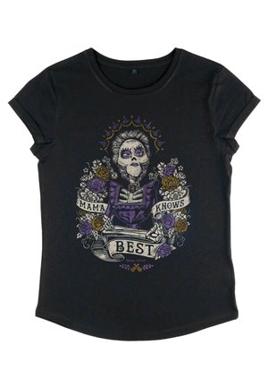 T-shirt nera con collo rotondo, caratterizzata da una stampa colorata di uno scheletro in un vestito viola con dettagli floreali e il testo "Mama Knows Best."