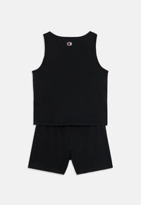 Ensemble débardeur et short en coton noir. Il présente un col rond et une taille élastique. Petit logo au dos du débardeur. Design simple.