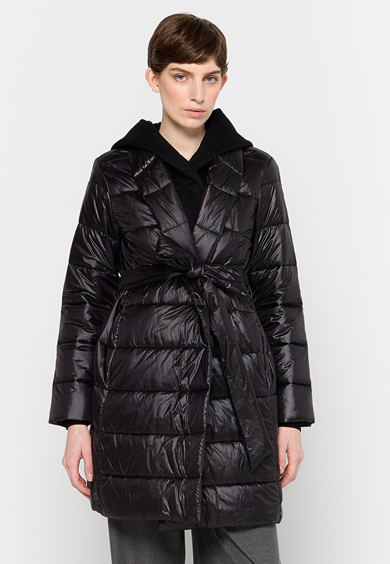 Czarna kurtka puchowa z szalem, z detalami w postaci paska oraz pikowanym wzorem. Ma długie rękawy i średnią długość.