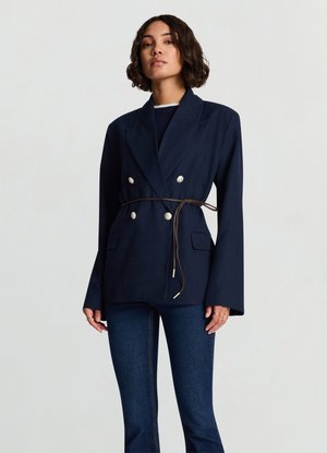 Marineblauer, doppelt geknöpfter Blazer mit tailliertem Gürtel, versehen mit silbernen Knöpfen, breiten Revers und Pattentaschen. Strukturierter Schnitt aus strukturiertem Stoff.