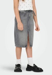 Pilkas džinsinis midi sijonas su priekiniu skeltu, aukštu liemeniu ir rišamu diržu. Puikiai derinamas su juodais loafer'iais ir baltais dryžuotais kojinaitėmis.