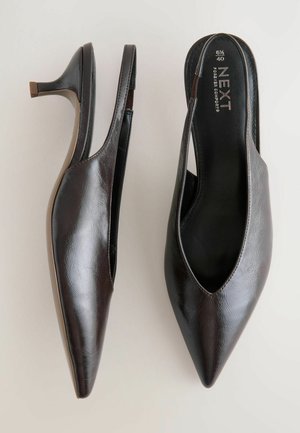 Rjave slingback pete s ostrim prstom in tankim petam, postavljene na svetli ozadju, ki prikazuje njihov eleganten dizajn.