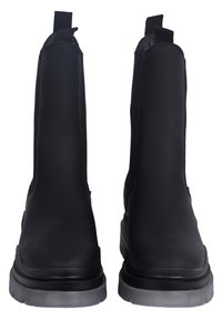 Botas negras de tobillo con un acabado mate suave, paneles laterales elásticos y tiradores. Presentan una suela gruesa de goma translúcida.