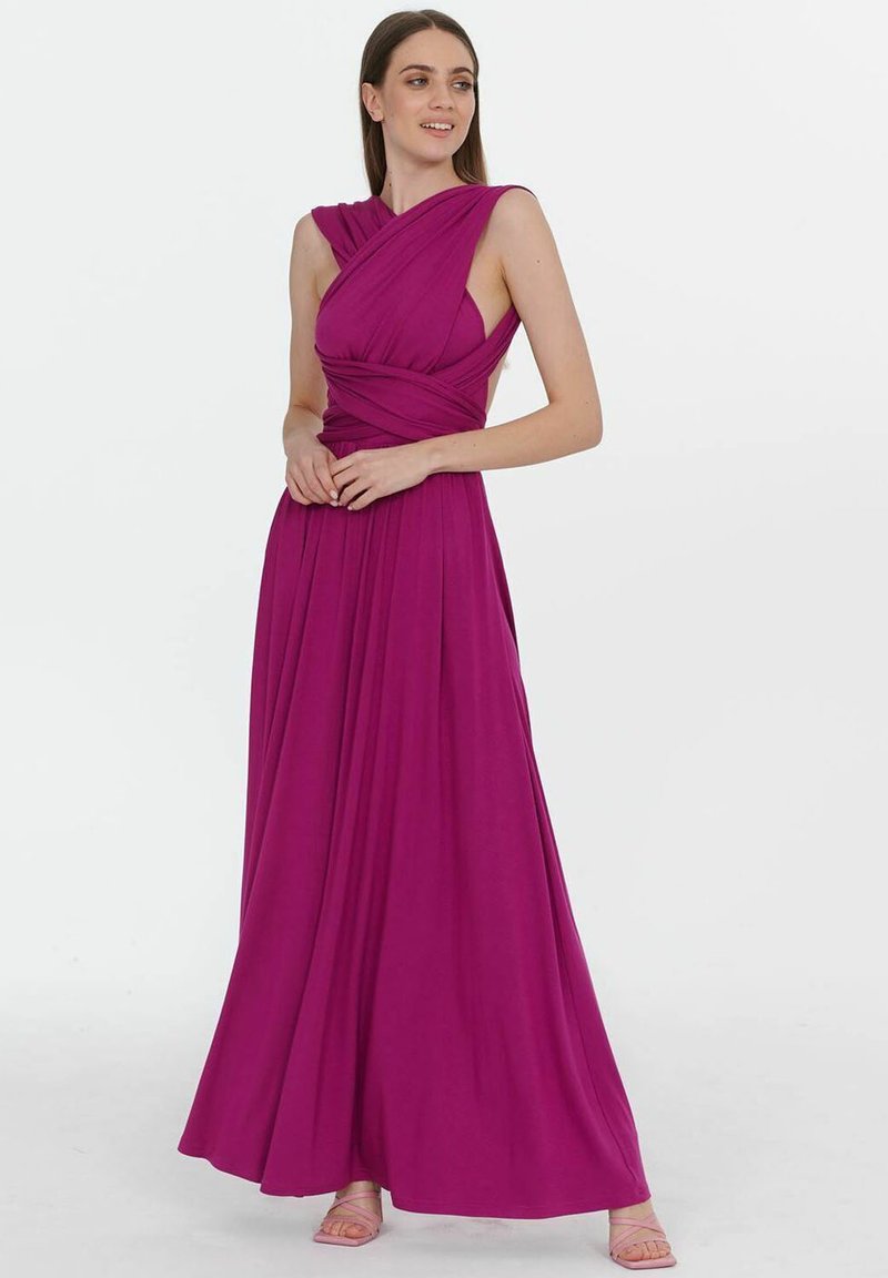 Dlouhá, splývavá večerní šaty v fuchsiové barvě s detailním zvratem v oblasti dekoltu a bezramenným designem. Hladká textura s dlouhým siluetou až na zem.