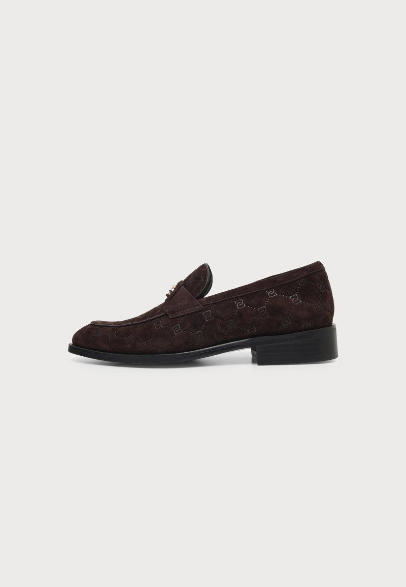 Mocassin en daim marron foncé avec un motif embossé subtil et un petit talon noir, montré de côté sur un fond clair uni.