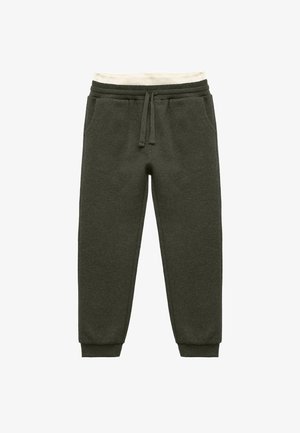 Pantalones de chándal de punto texturizado en verde oscuro, con cintura elástica, forro interior color crema y puños ajustados. Presenta dos bolsillos laterales.