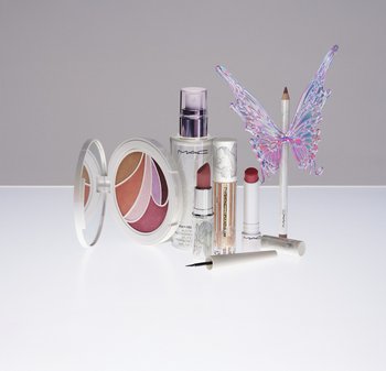 MAC makeup products including a colorful eyeshadow palette, lipsticks, setting spray, lip gloss, eyeliner, and a pencil with iridescent butterfly wings.