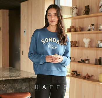 Blauwe sweatshirt met witte "SUNDAY Club" grafiek, ontspannen pasvorm, gecombineerd met zwarte broek. Glad materiaal en casual ontwerp.