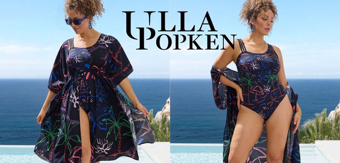 Zwart badpak met kleurrijke tropische patronen, gecombineerd met een vloeiende zwarte cover-up met brede mouwen en een striksluiting. Zilveren sandaaltjes.