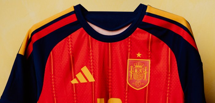Maillot de football espagnol rouge et bleu foncé avec logo Adidas jaune et blason national avec une étoile au-dessus.