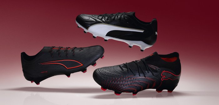 Trois chaussures de football noires avec des accents rouges et blancs suspendues sur un fond dégradé rouge.