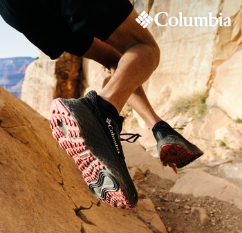 Schwarze Columbia Laufschuhe mit einer strukturierten Oberseite und einer lebhaften roten Gummisohle, ausgestattet mit einem Schnürsystem und einem ausgeprägten Profil.