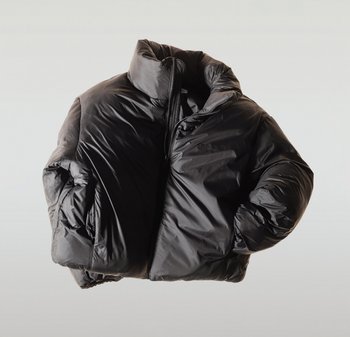 Chaqueta acolchada negra con cuello alto, relleno grueso, cierre de cremallera y puños elásticos. Material exterior liso y brillante.