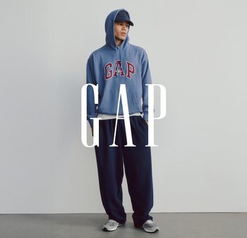 Kék kapucnis pulóver "GAP" logóval, laza illeszkedésű tengerészkék nadrággal és szürke sportcipőkkel párosítva. Egyszerű design és puha anyagok.