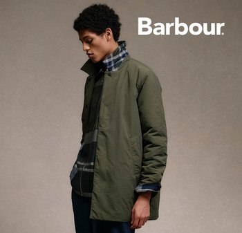 Olive green outer jacket with a button closure, high collar, and side pockets, layered over a black and blue plaid shirt.