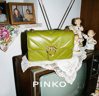 Green leather handbag with gold bird clasp on crocheted doily atop vintage TV, surrounded by porcelain angel figurines and framed photos.