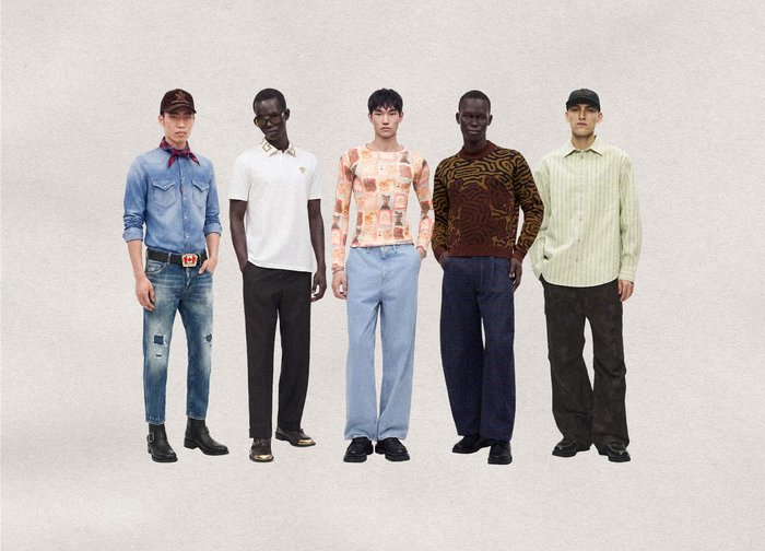 Cinq hommes se tiennent côte à côte vêtus de tenues décontractées et à motifs variés, comprenant du denim, des polos, des pulls et des pantalons, sur un fond uni.