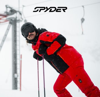 Veste et pantalon de ski rouges et noirs avec des accents orange, matériau imperméable, surface texturée, bâtons de ski, arrière-plan enneigé et logo visible.