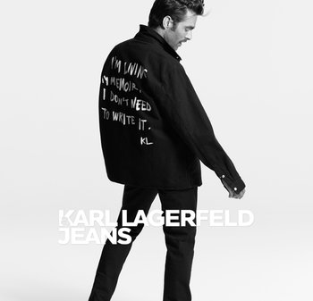 Black oversized shirt with white handwritten text on the back; paired with black pants. Features a relaxed fit and buttoned cuffs.