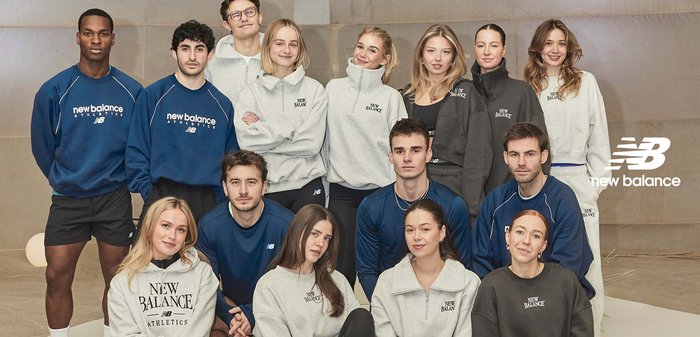 Group of diverse young adults wearing New Balance athletic apparel, posing indoors with relaxed and confident expressions.