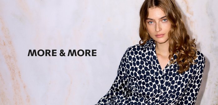 Hemdblusenkleid mit marineblauem und weißem Polka-Dot-Muster, ausgestattet mit einem Kragen, langen Ärmeln und einem Taillengürtel für eine figurbetonte Silhouette.