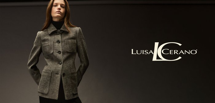 Gray, textured blazer with a structured shape, featuring large buttons, chest pocket, and notched collar, against a dark backdrop.