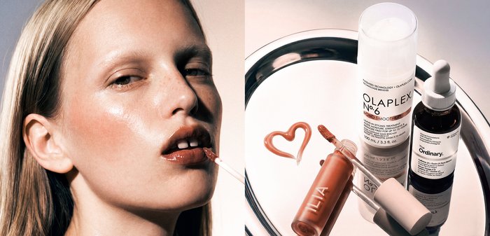 Femme appliquant un gloss à lèvres marron à côté de produits de soin capillaire et de soins de la peau sur une surface réfléchissante avec un cœur dessiné en gloss.