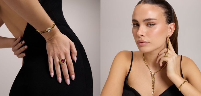 Kobieta z gładko zaczesanymi włosami nosi złoty zestaw biżuterii, w tym długie kolczyki w kształcie łańcuszka, naszyjnik w kształcie litery Y, pierścionek oraz bransoletkę, ubrana w czarny top.