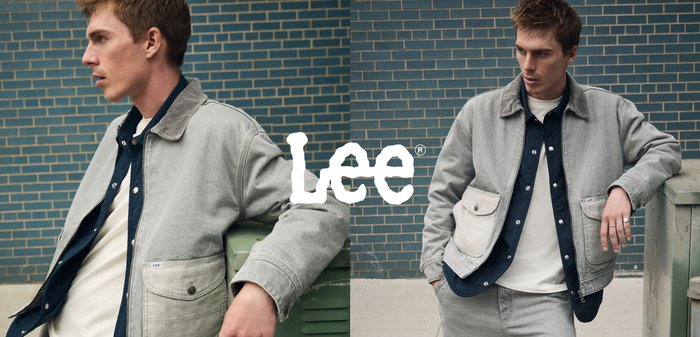 Grå og marineblå jakke med kordfløyelskrage, frontlommer og sølvknappdetaljer, brukt over en hvit skjorte og grå bukser.