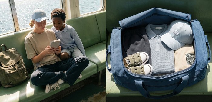 Deux enfants sont assis sur un banc de bateau, regardant un smartphone ; à côté d'eux, un sac ouvert contient des vêtements pliés et des chaussures.
