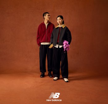 Deux mannequins posent devant un fond texturé marron. Le mannequin masculin porte un sweat à capuche zippé bordeaux et un pantalon noir. La mannequin féminine porte une veste bomber noire avec un col beige, une chemise blanche et un pantalon foncé, tenant des orchidées violettes. Tous deux portent des baskets.