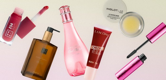 Various cosmetic products arranged on a light surface, including lip tint, hand wash, perfume, blush tint, lip repair mask, and mascara.