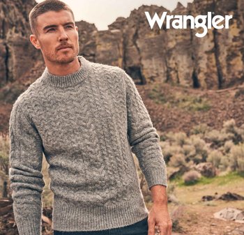 Grå kabelstickad tröja med hög krage, ribbad mudd och fåll. Strukturerad tyg mot en naturlig utomhusbakgrund. Wrangler-logotyp närvarande.